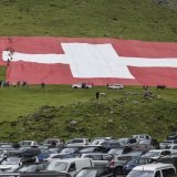 Déchiré par une bourrasque de vent sur son côté gauche, le drapeau géant est en cours de réparation. KEYSTONE/GIAN EHRENZELLER